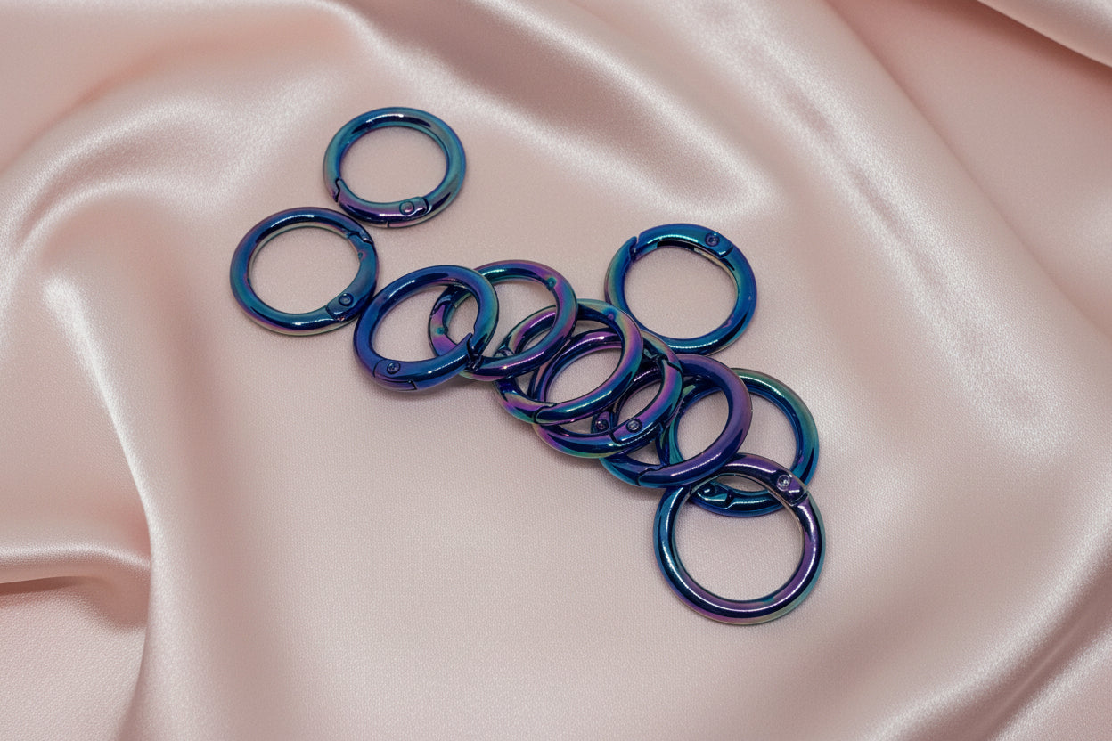 Iridescent blue-purple jump rings for DIY jewelry making on pink satin