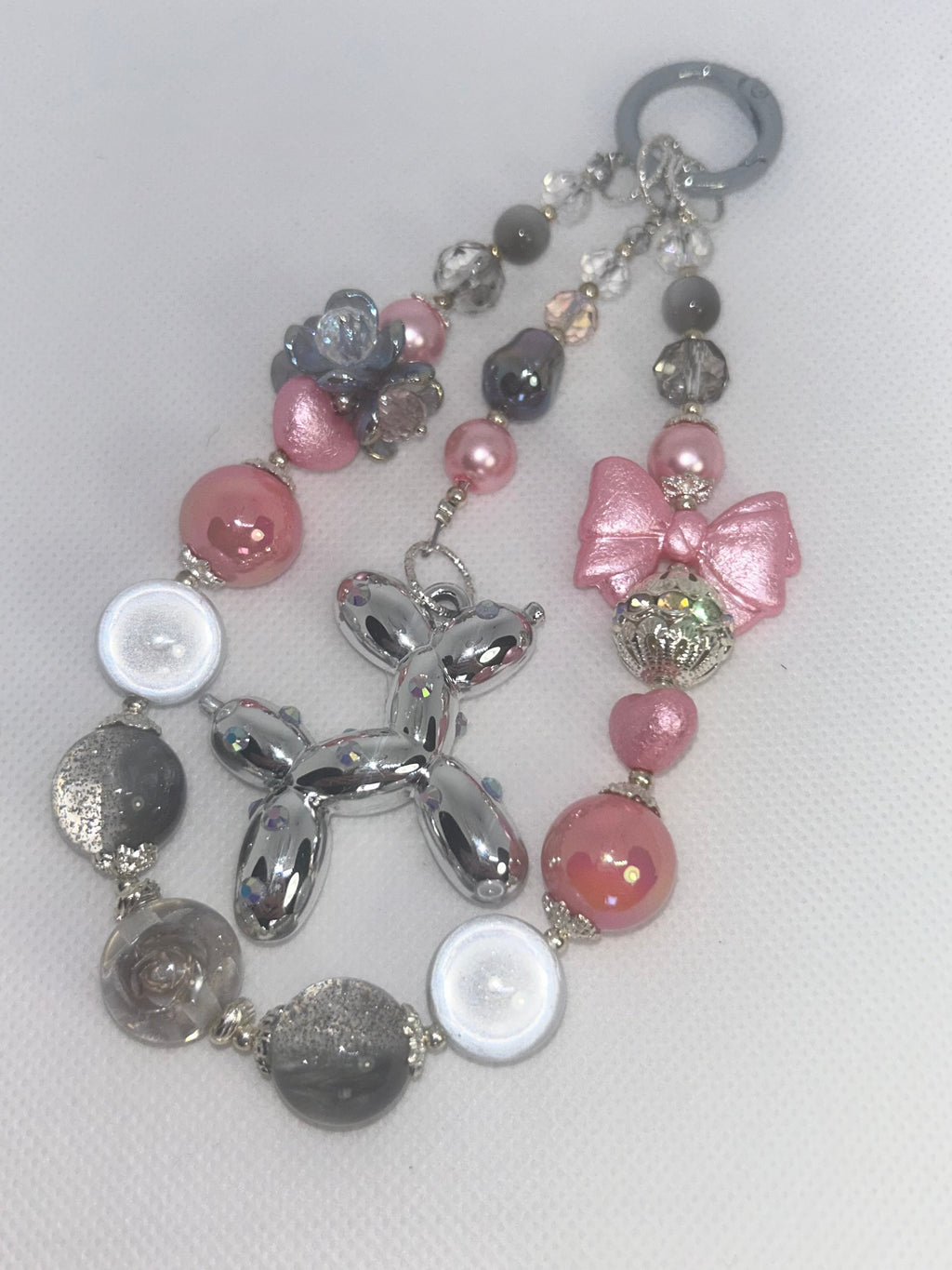 Handmade beaded keychain with silver balloon dog, pink bow, and pastel beads for DIY accessories
