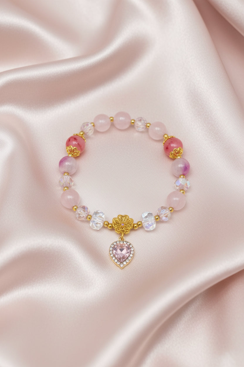 Handmade beaded bracelet with pink stones, gold accents, and heart charm on satin, perfect for DIY jewelry crafts