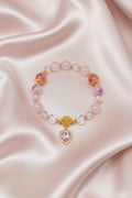 Handmade beaded bracelet with pink stones, gold accents, and heart charm on satin, perfect for DIY jewelry crafts