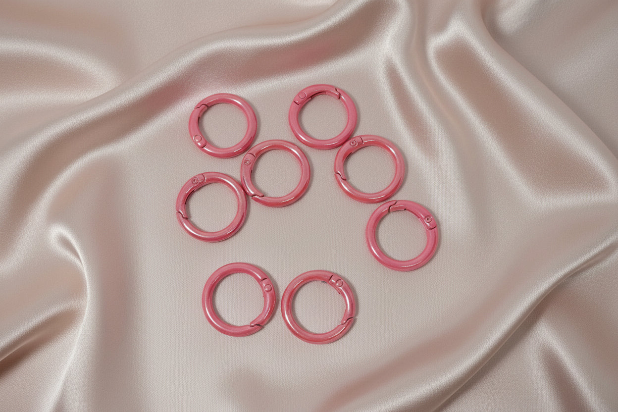 Pink snap rings for DIY jewelry making on satin fabric