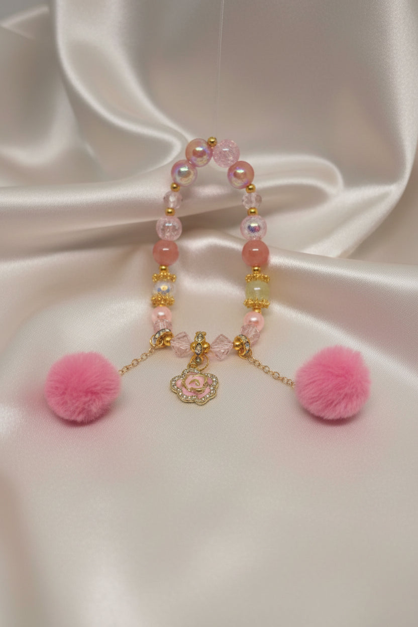 Handmade pink beaded bracelet with rose charm and fluffy pom poms, perfect for DIY accessories