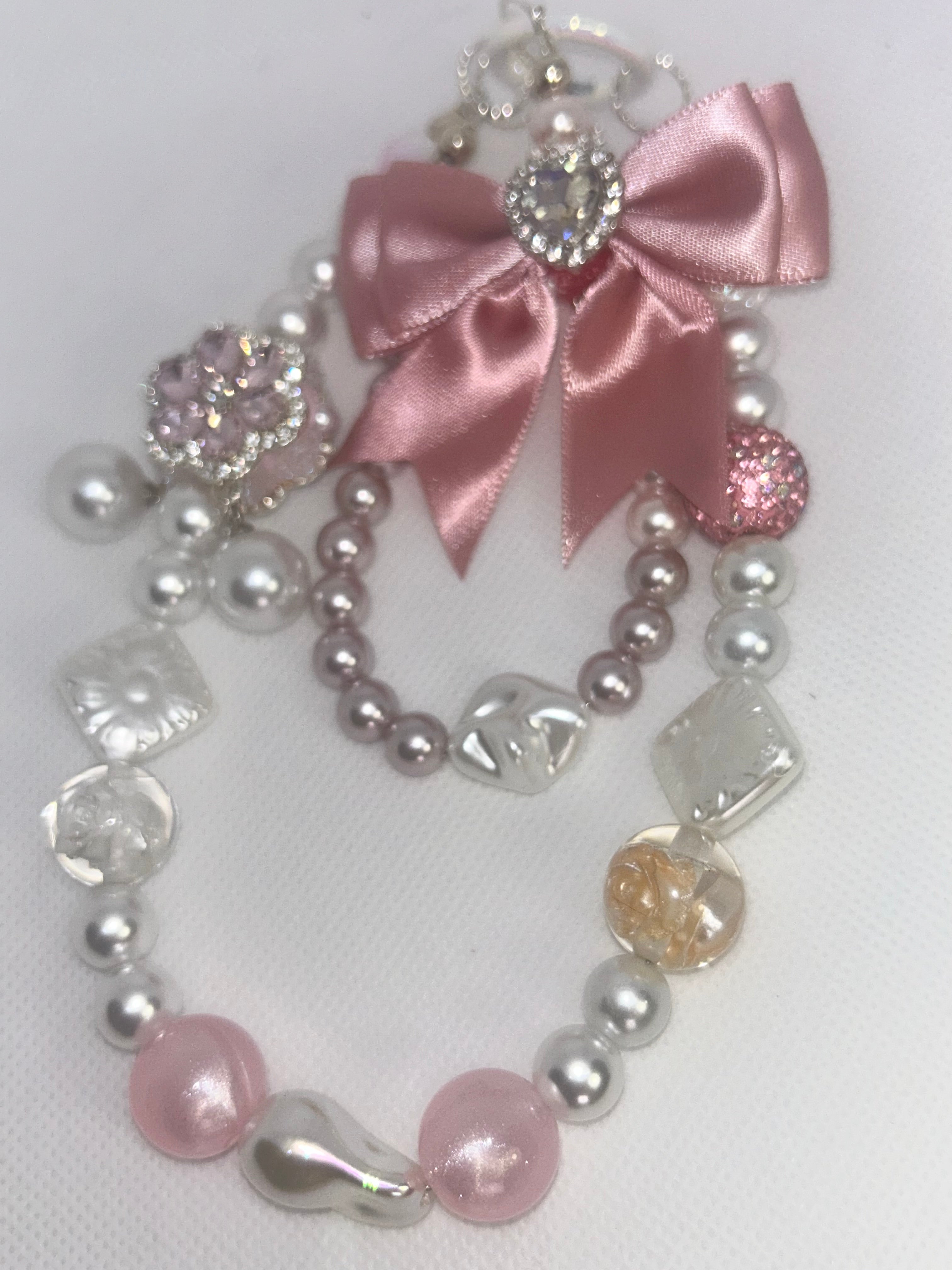 Handmade beaded necklace with pink satin bow, pearls, and crystal charms for DIY accessories
