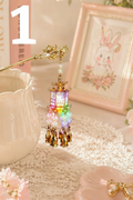Handmade beaded lantern charm with gold tassels and pastel beads, perfect for DIY accessories and crafts.