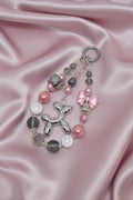 Handmade beaded keychain with balloon dog charm, pink bow, and pearl beads on satin