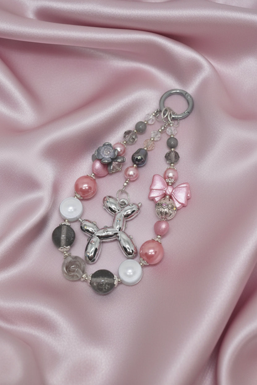 Handmade beaded keychain with balloon dog charm, pink bow, and pearl beads on satin