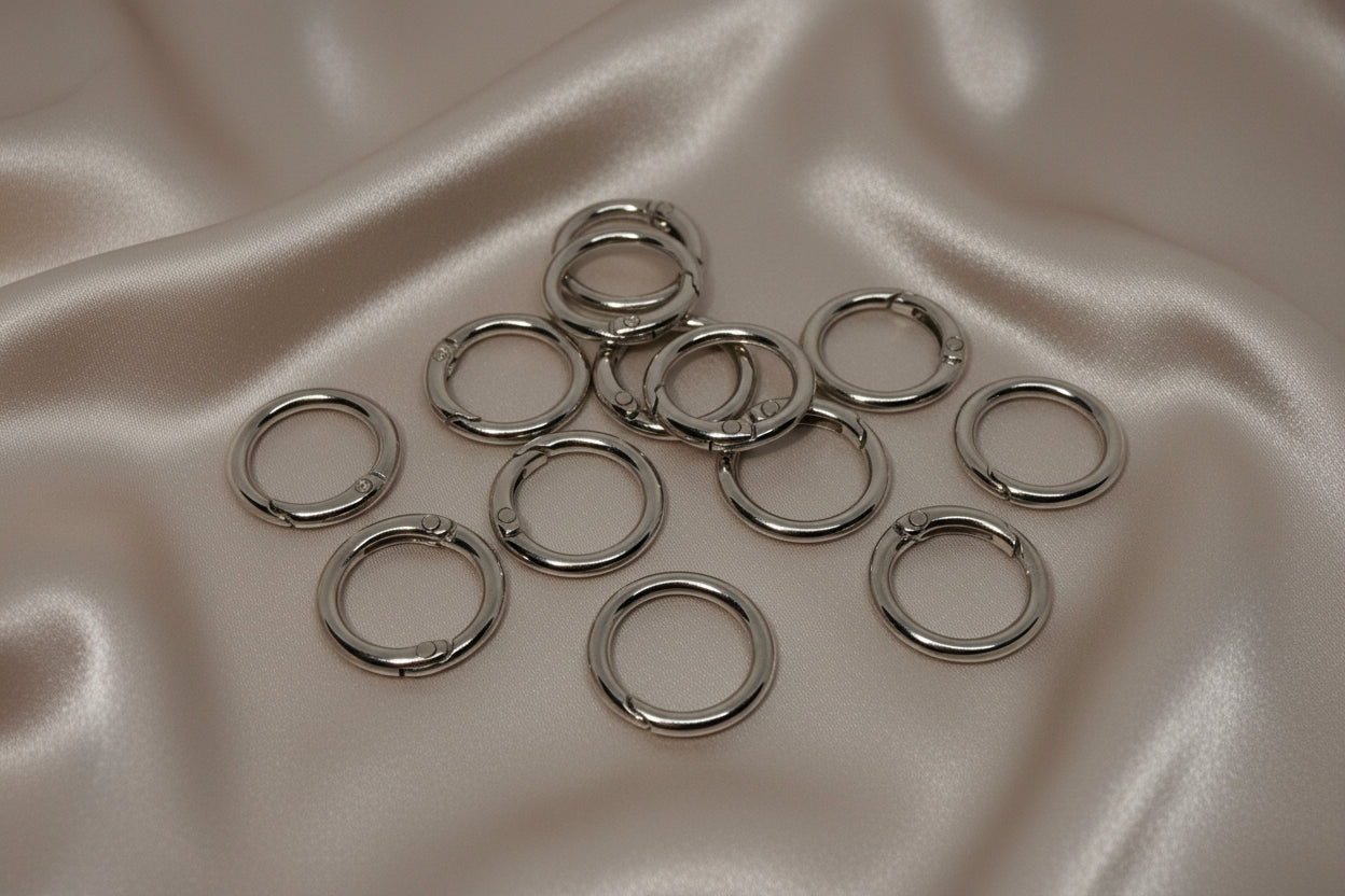 Silver jump rings for DIY jewelry making on satin fabric