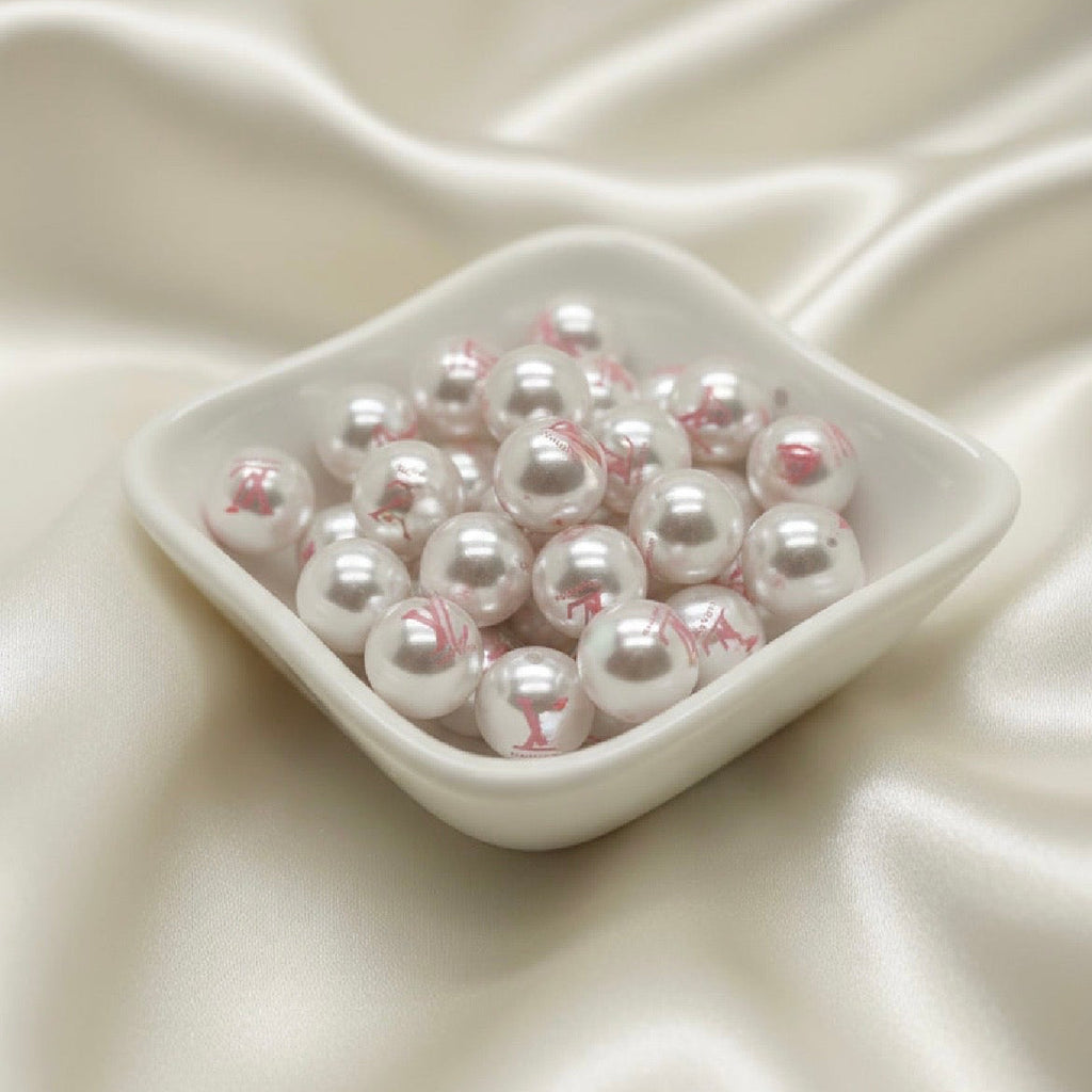 White pearl beads with pink floral print in ceramic dish, ideal for DIY jewelry making and crafts