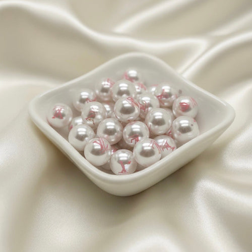 White pearl beads with pink floral print in ceramic dish, ideal for DIY jewelry making and crafts