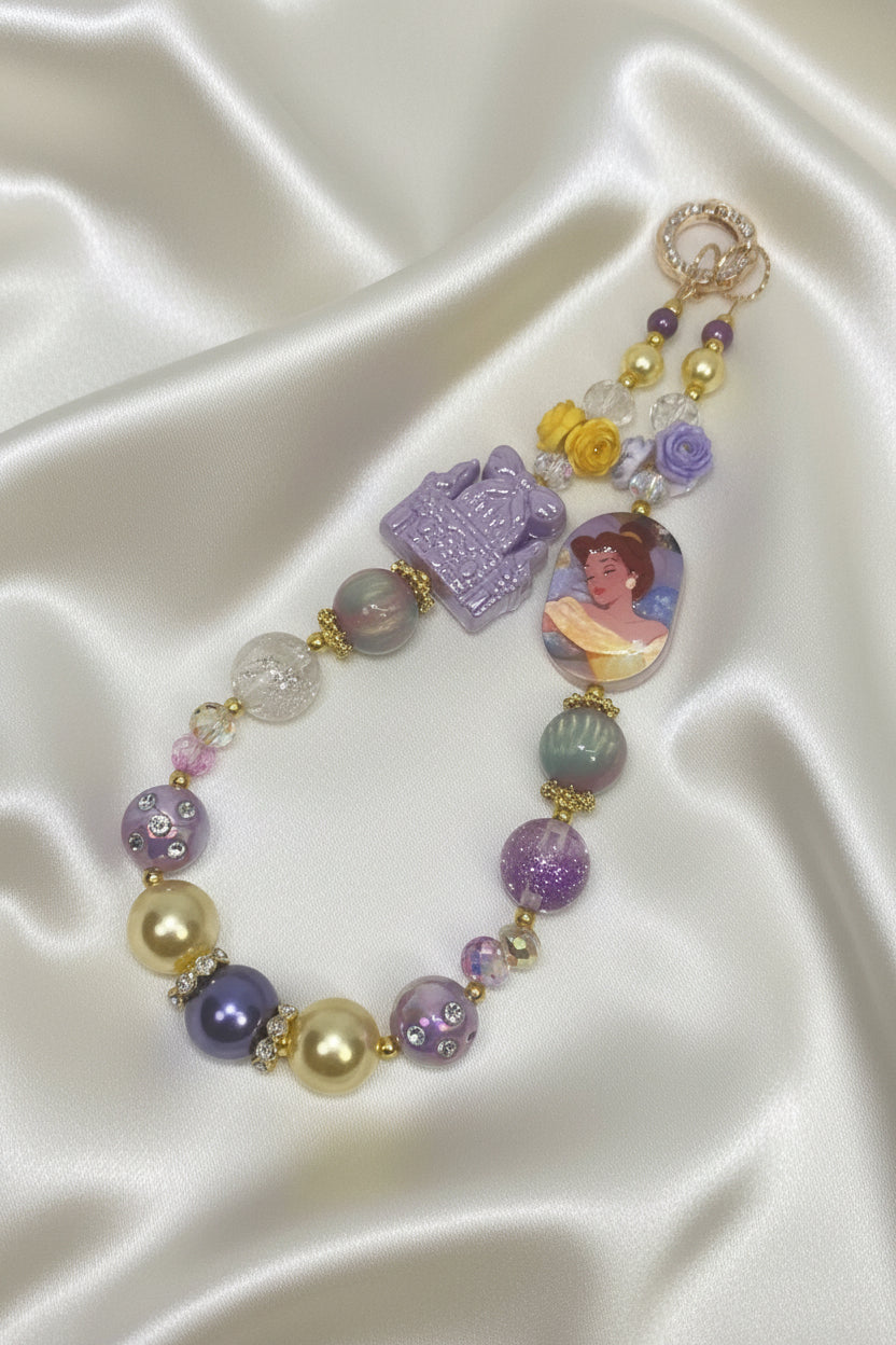 Handmade beaded necklace with purple, gold, and floral charms on satin, perfect for DIY accessories.