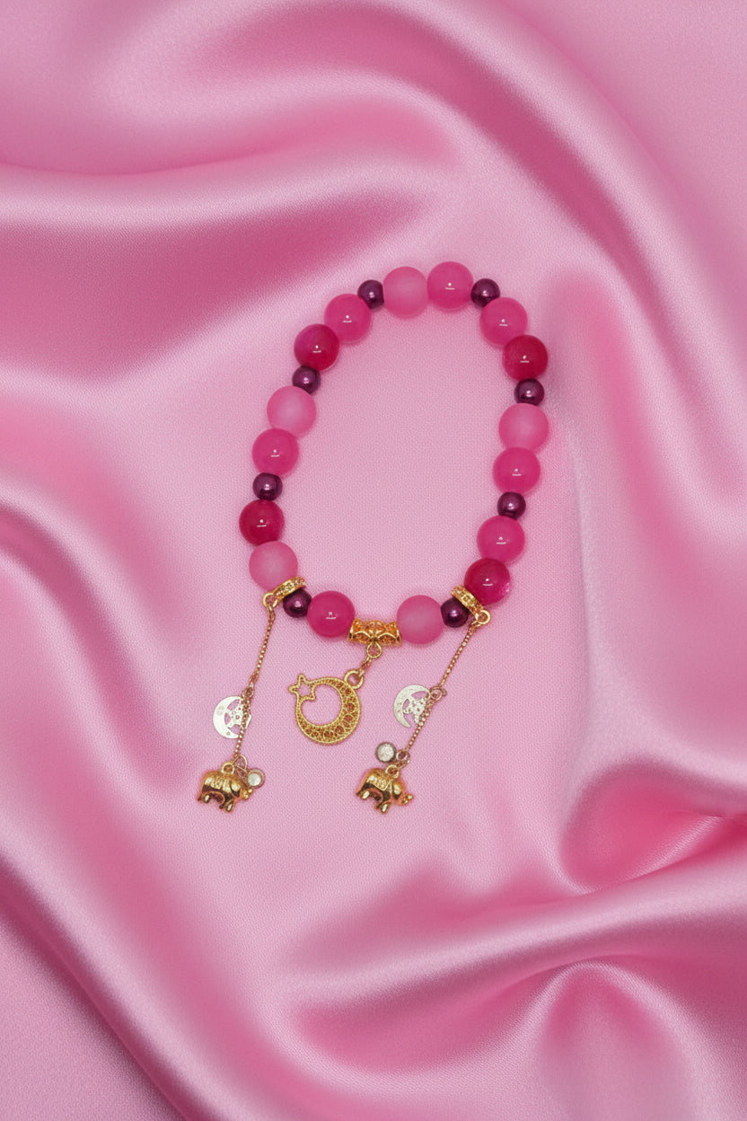Pink beaded bracelet with gold elephant and moon charms, handmade DIY accessory on satin