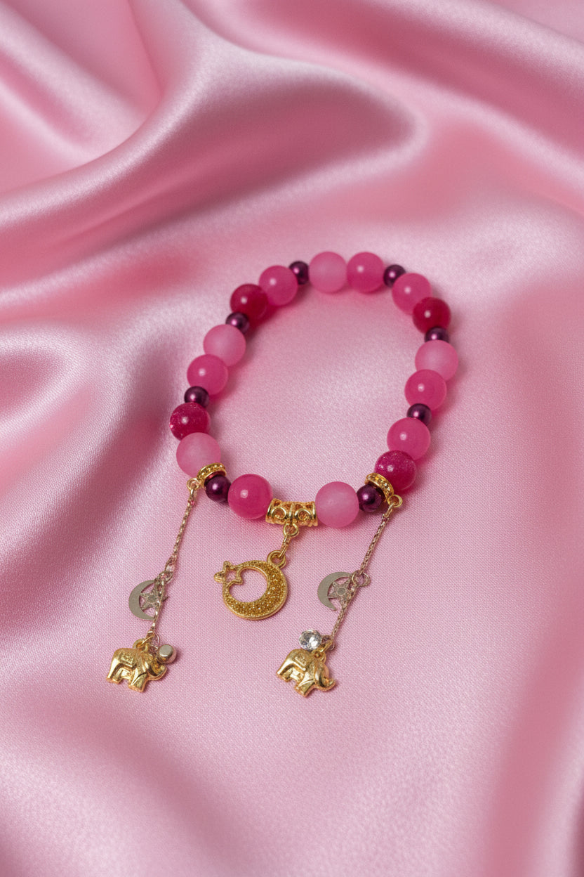 Pink beaded bracelet with gold elephant and moon charms, handmade DIY accessory on satin