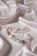 Handmade pink beaded necklace with unicorn charm, pearls, and crystal beads on satin fabric